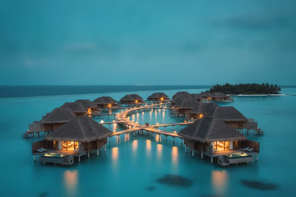 Maldives overwater bungalows glowing at dusk