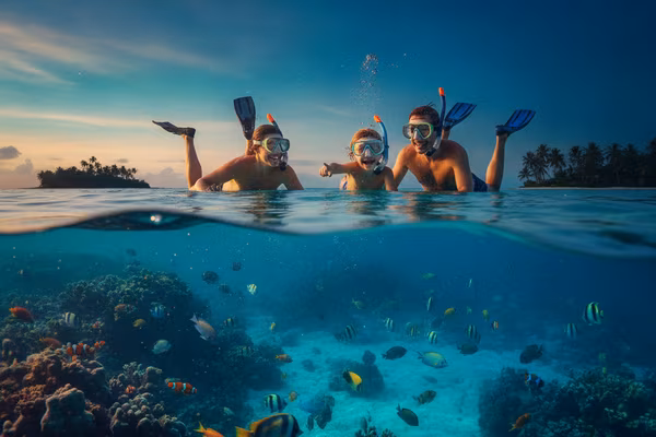 Family snorkelling together in clear shallow water