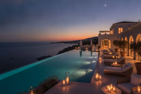 French Riviera cliffside terrace with infinity pool at twilight